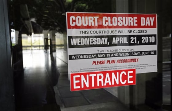 An empty corridor is seen through a locked door with a sign advising that the Clara Shortridge Foltz Criminal Justice Center in Los Angeles is closed for an unpaid furlough day on Wednesday. 